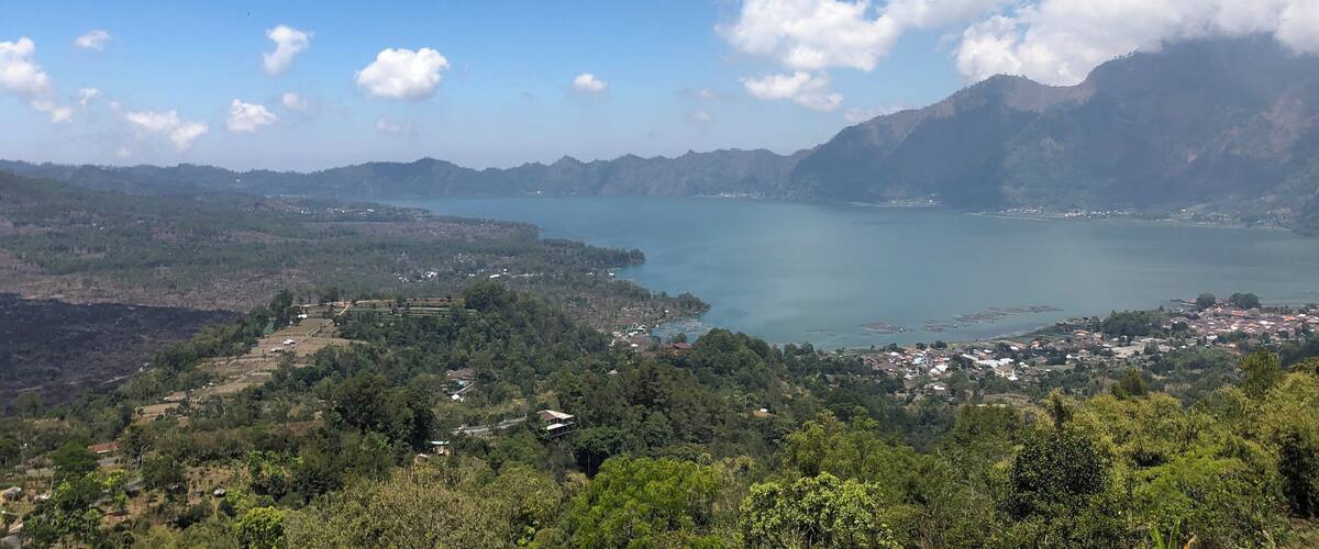 A mountainous landscape with a lake and scattered buildings.