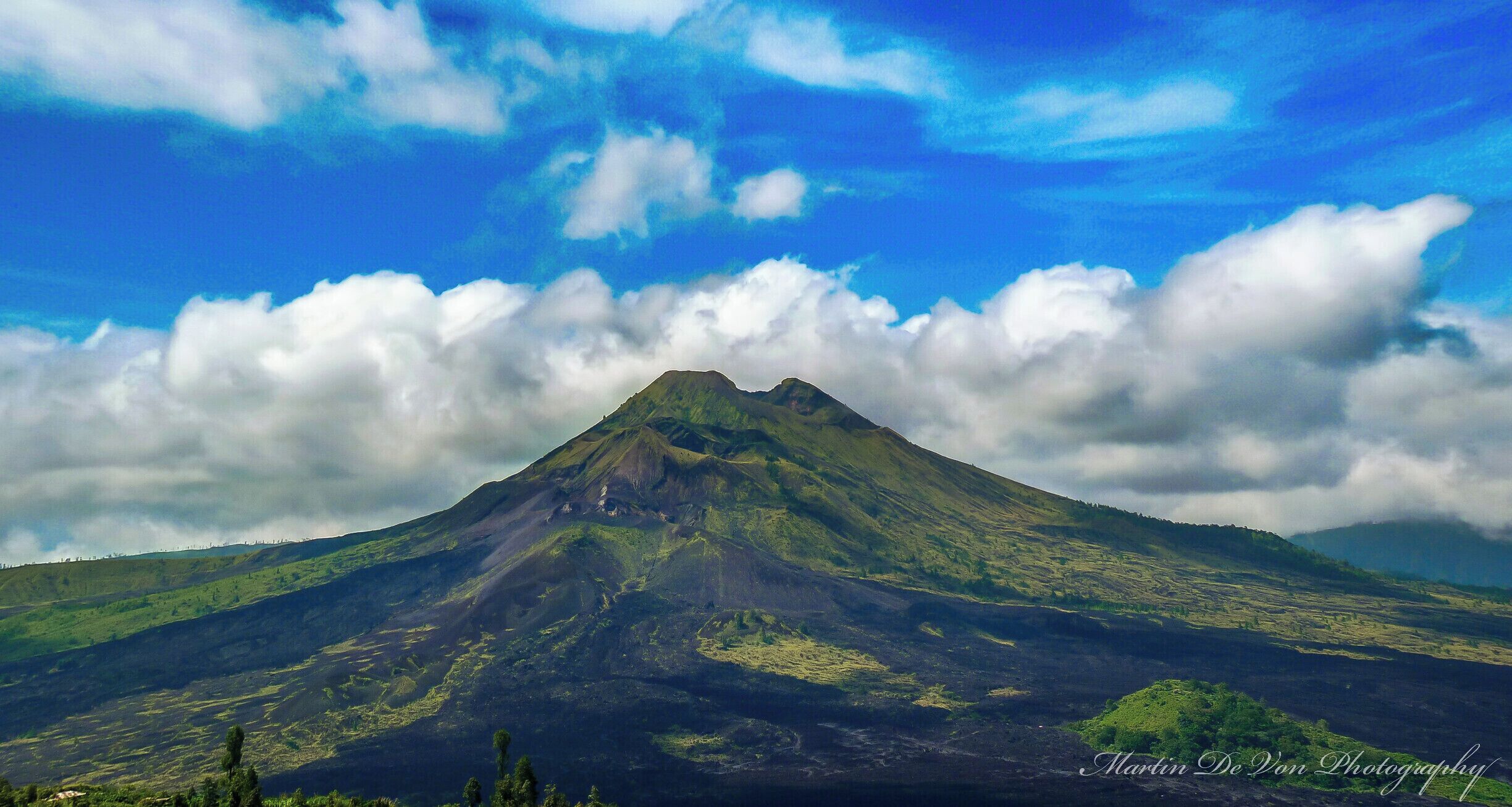 Mount Batur is the easiest climb of the three volcanos and provides spectacular views of Lake Batur and the ocean. It is also Bali’s most active volcano, so check whether it is safe to climb before you go.

Most people do the climb as an organized tour, but you can do it on your own if you prefer. If you decide to do the trek without a guide, be prepared to deal with local guides in Kintamani, the town where the trek starts, who have a reputation for being extremely pushy and doing almost anything to hinder people without a guide to reach the summit.

The track starts out as dirt path, but as it quickly gets steeper it also gets rockier and after a while vegetation is mainly limited to grasses growing among the rocks. Before reaching the summit, a small vender sells refreshments.

On the summit views reach as far as Mount Rinjani, and if you have a guide, he or she might cook you an egg boiled in volcanic steam before the descent.

Hight: 1717 meter

Difficulty: The trek is straight forward, so if you are in decent shape, you shouldn’t have many problems.

Trip length: It takes one to two hours to reach the summit and the same time to get down, but you should also include time to enjoy the views and explore the rim of the crater.