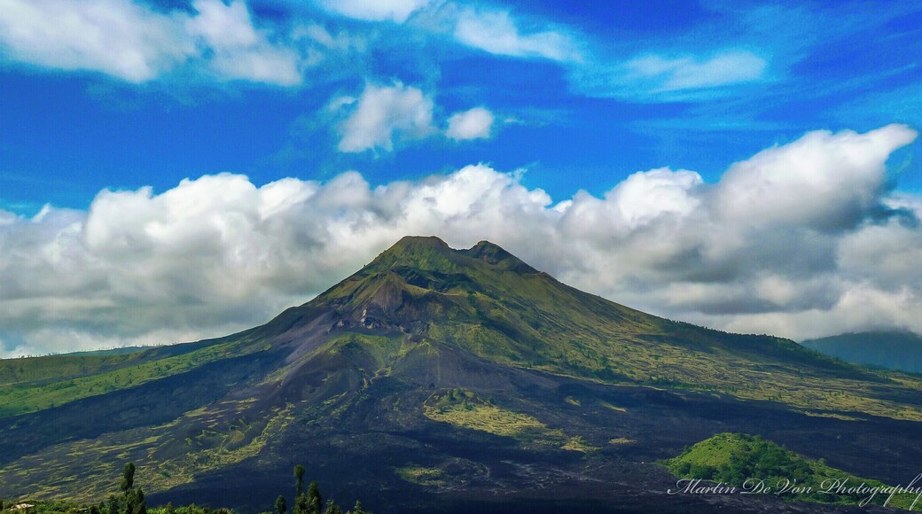Mount Batur is the easiest climb of the three volcanos and provides spectacular views of Lake Batur and the ocean. It is also Bali’s most active volcano, so check whether it is safe to climb before you go.
Most people do the climb as an organized tour, but you can do it on your own if you prefer. If you decide to do the trek without a guide, be prepared to deal with local guides in Kintamani, the town where the trek starts, who have a reputation for being extremely pushy and doing almost anything to hinder people without a guide to reach the summit.
The track starts out as dirt path, but as it quickly gets steeper it also gets rockier and after a while vegetation is mainly limited to grasses growing among the rocks. Before reaching the summit, a small vender sells refreshments.
On the summit views reach as far as Mount Rinjani, and if you have a guide, he or she might cook you an egg boiled in volcanic steam before the descent.
Hight: 1717 meter
Difficulty: The trek is straight forward, so if you are in decent shape, you shouldn’t have many problems.
Trip length: It takes one to two hours to reach the summit and the same time to get down, but you should also include time to enjoy the views and explore the rim of the crater.