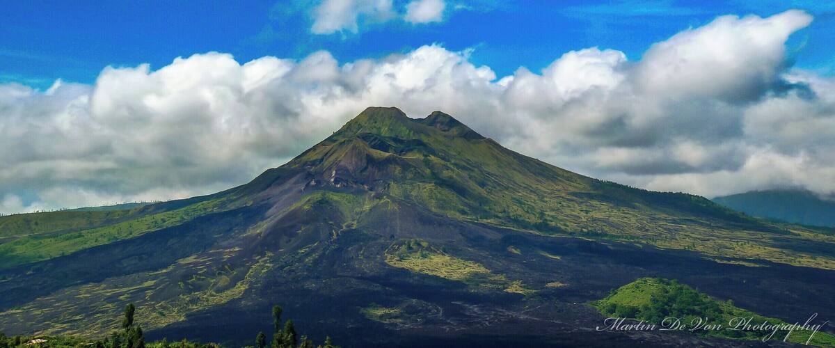 Mount Batur is the easiest climb of the three volcanos and provides spectacular views of Lake Batur and the ocean. It is also Bali’s most active volcano, so check whether it is safe to climb before you go.
Most people do the climb as an organized tour, but you can do it on your own if you prefer. If you decide to do the trek without a guide, be prepared to deal with local guides in Kintamani, the town where the trek starts, who have a reputation for being extremely pushy and doing almost anything to hinder people without a guide to reach the summit.
The track starts out as dirt path, but as it quickly gets steeper it also gets rockier and after a while vegetation is mainly limited to grasses growing among the rocks. Before reaching the summit, a small vender sells refreshments.
On the summit views reach as far as Mount Rinjani, and if you have a guide, he or she might cook you an egg boiled in volcanic steam before the descent.
Hight: 1717 meter
Difficulty: The trek is straight forward, so if you are in decent shape, you shouldn’t have many problems.
Trip length: It takes one to two hours to reach the summit and the same time to get down, but you should also include time to enjoy the views and explore the rim of the crater.