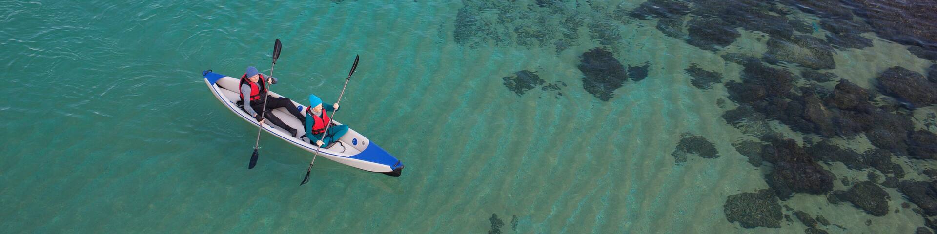 High angle view of mature couple kayaking in Mediterranean sea, Shavei Zion beach. The sea water is clear and sea bottom is visible.