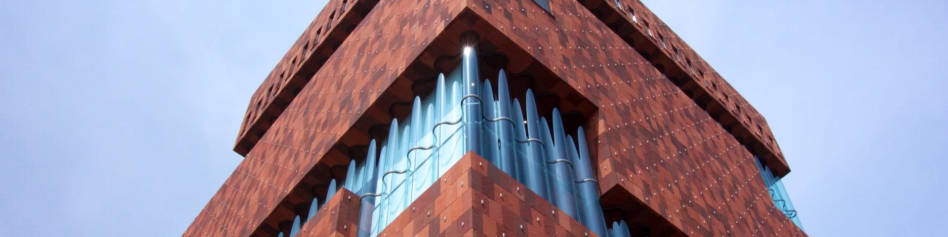A tall, red-brick tower with a unique geometric pattern and blue accents.