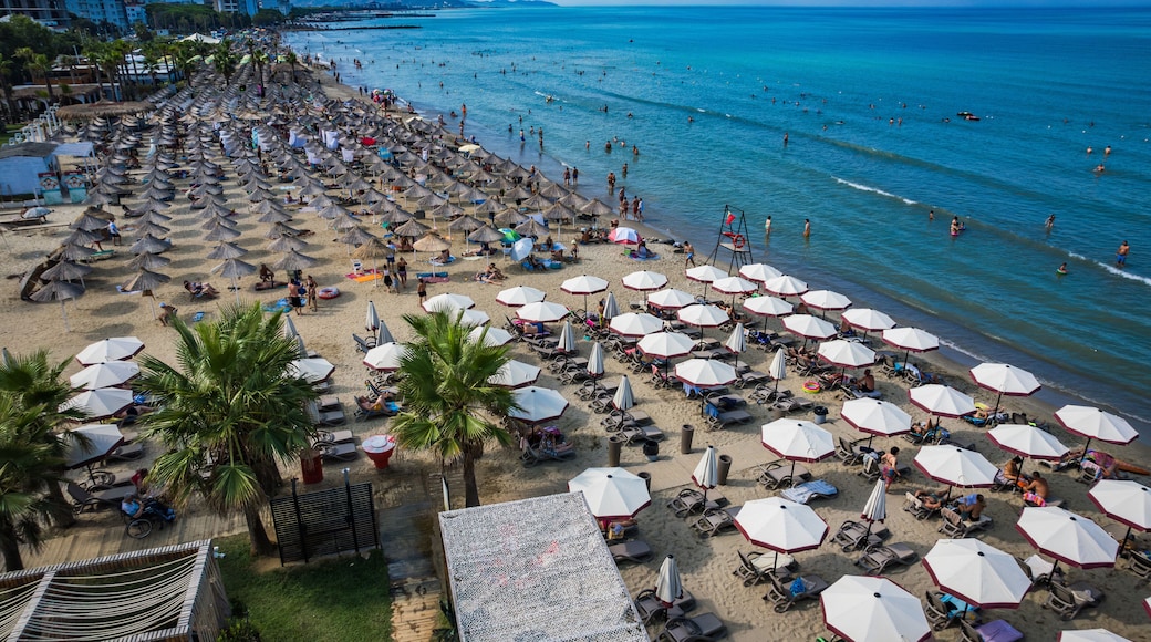 Golem, Durres, Albania - 22 august 2023: Aerial view to sandy beach full of umbrellas and people in summer season 2023