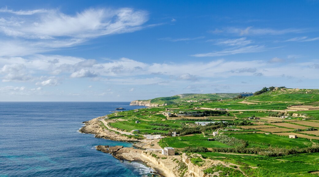 Mgarr, Malta - Panorama of Xatt l-Aħmar bay and cliffs in Malta at with beautiful colorful sky and golden rocks taken from near fort chambray