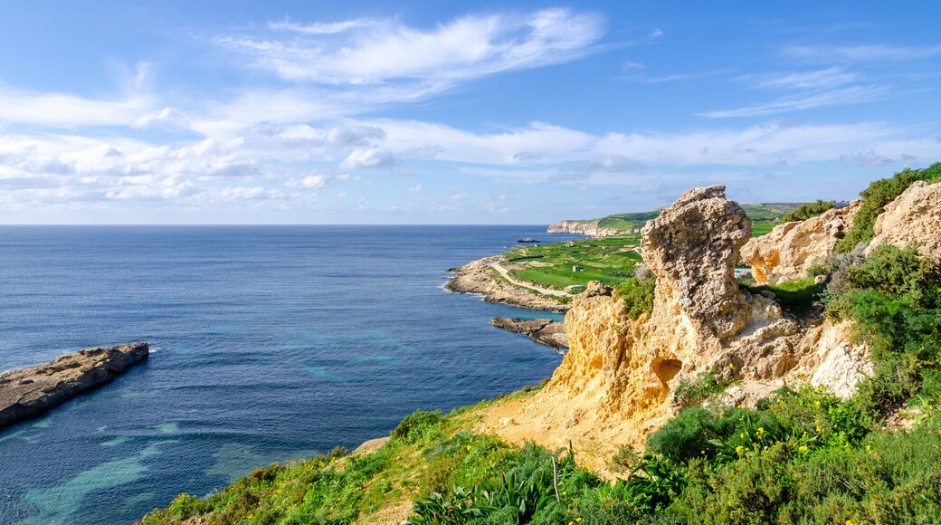 Mgarr, Malta - Panorama of Xatt l-Aħmar bay and cliffs in Malta at with beautiful colorful sky and golden rocks taken from near fort chambray