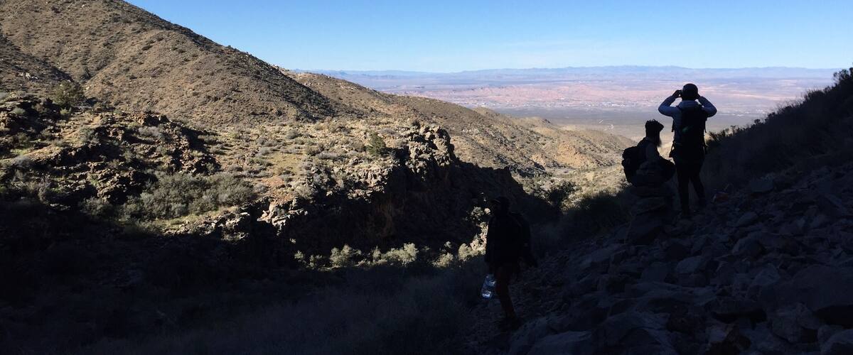A mountainous landscape with hikers on a trail.