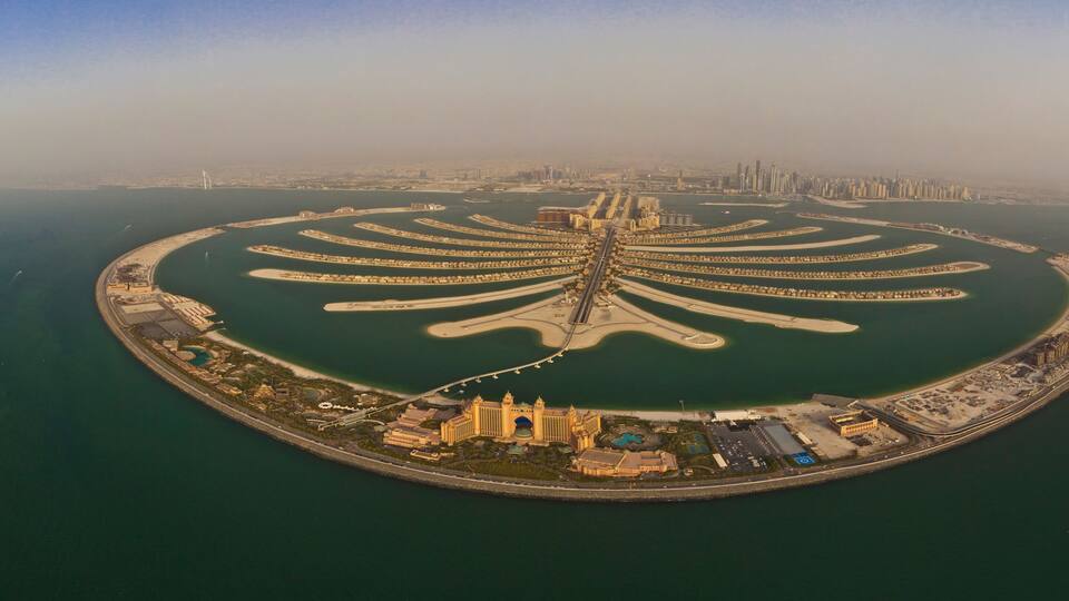 A large, palm-shaped island with a central building complex and a surrounding marina.
