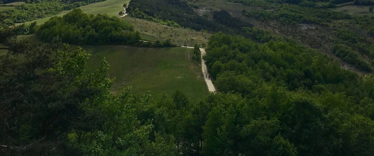 A mountainous landscape with a winding path and a lake.