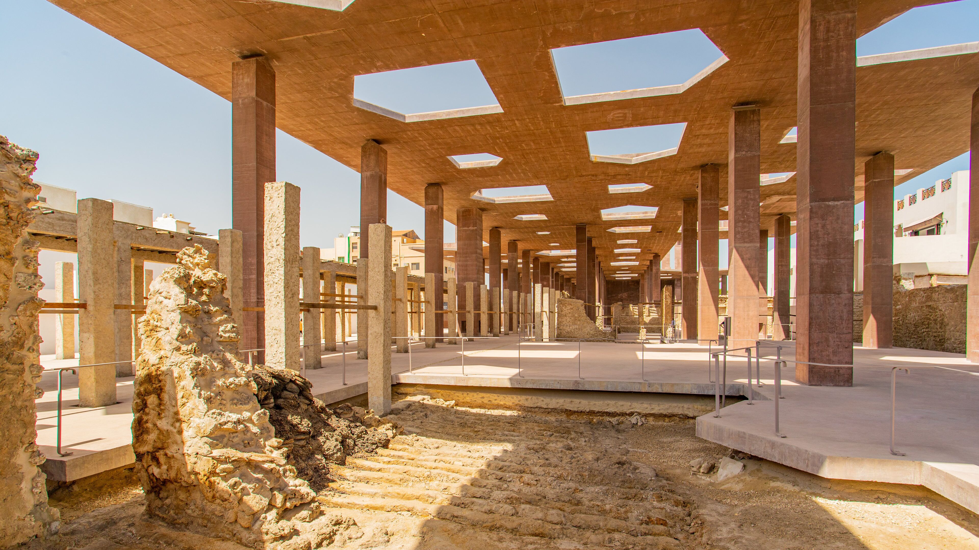 An ancient ruin with stone columns and a central open space.