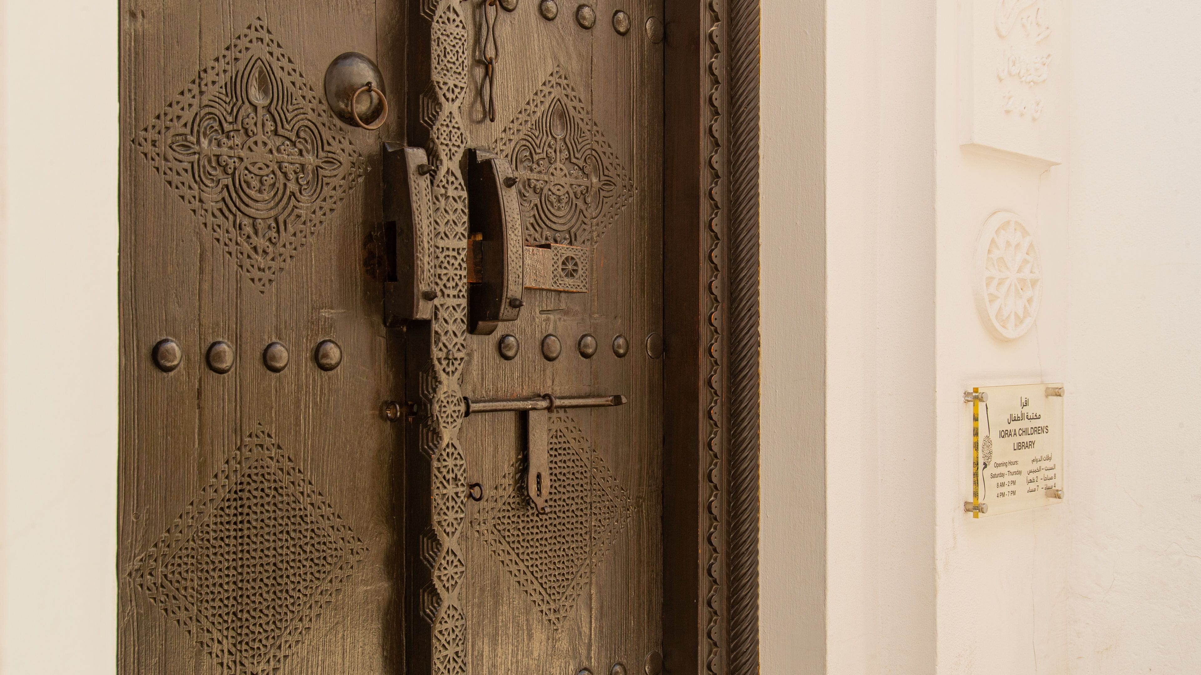 A wooden door with intricate carvings and a metal latch.