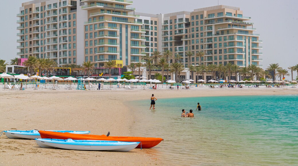 Muharraq which includes a coastal town, a sandy beach and general coastal views