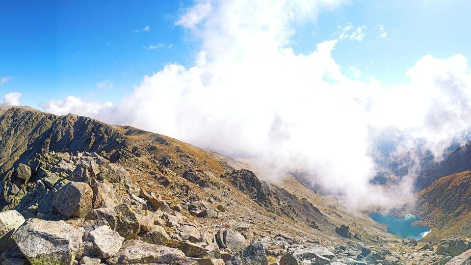A mountain landscape with rocky terrain and a lake.
