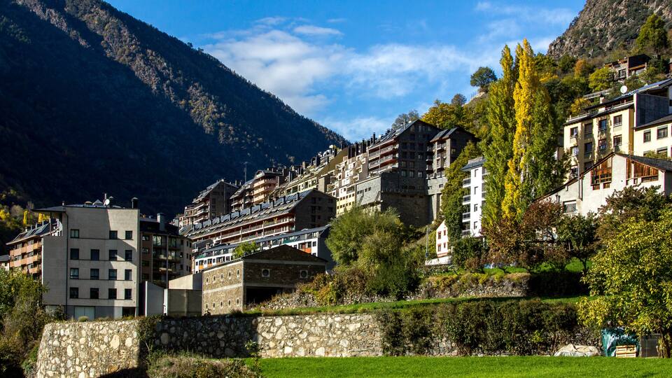 A mountainous village with stone buildings and lush greenery.