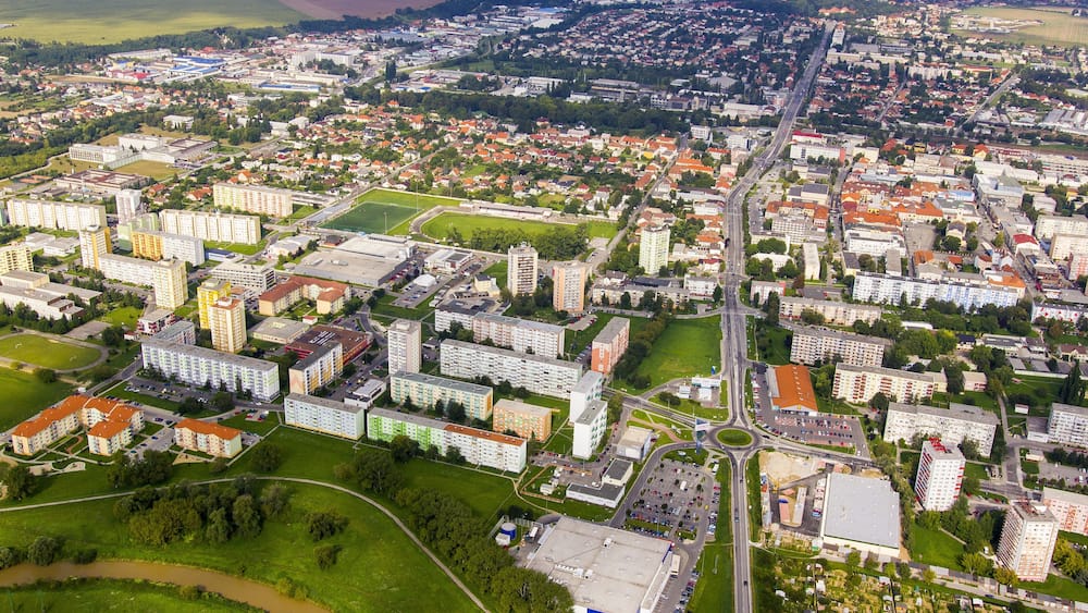 An aerial view of a city with residential areas, commercial buildings, and a river.