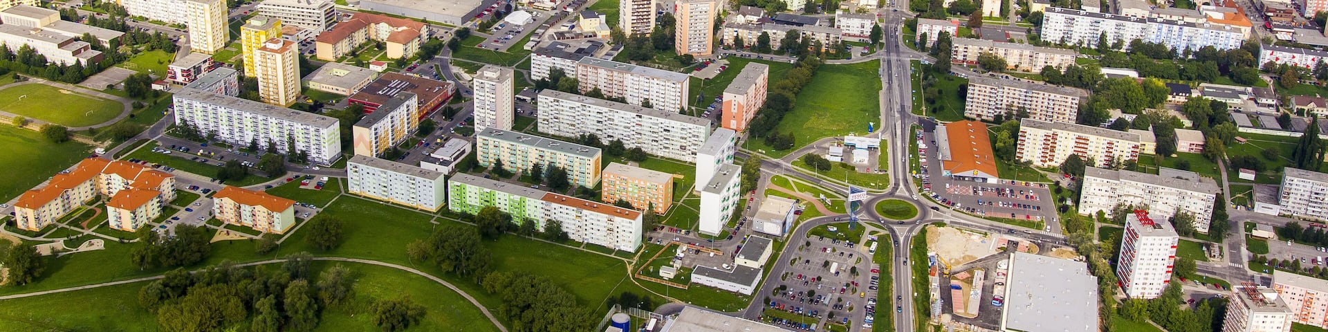 An aerial view of a city with residential areas, commercial buildings, and a river.