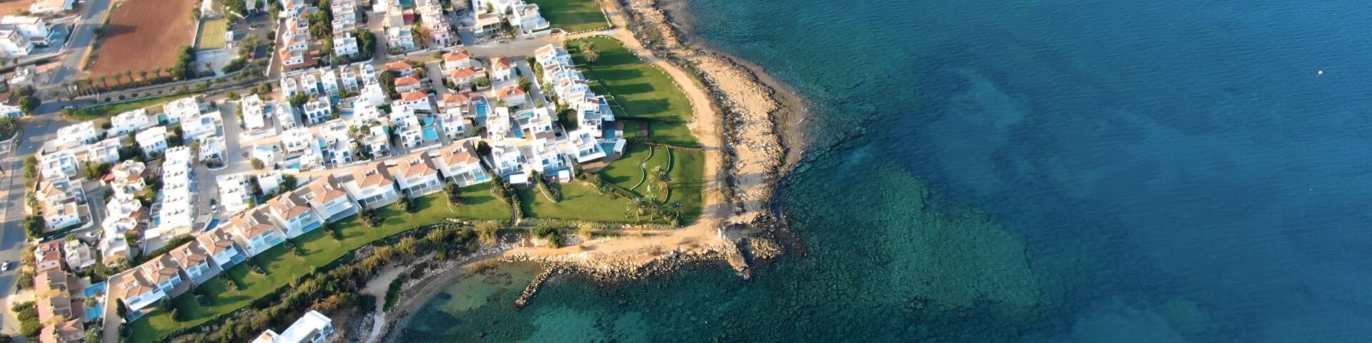 Drone shooting panorama of the coastline of the city with luxury hotels, villas, bays, ports with stylish yachts, sandy and rocky beaches and calm sea with clear blue water in Larnaca Cyprus