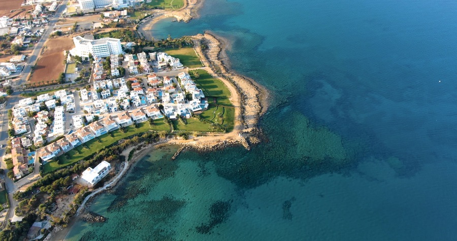 Drone shooting panorama of the coastline of the city with luxury hotels, villas, bays, ports with stylish yachts, sandy and rocky beaches and calm sea with clear blue water in Larnaca Cyprus