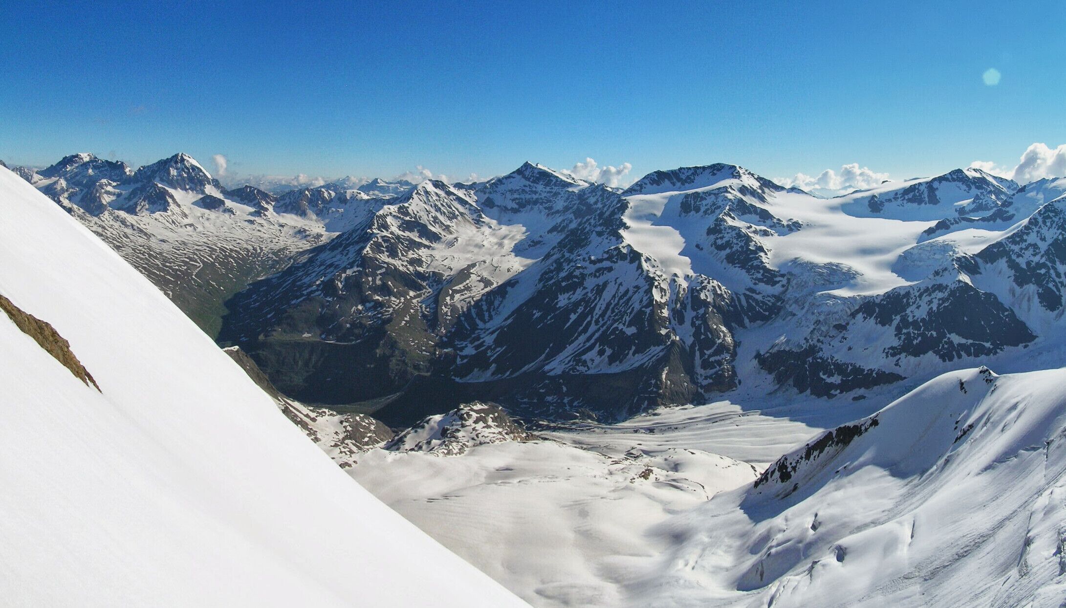 A snow-covered mountain range with sharp peaks and deep valleys.