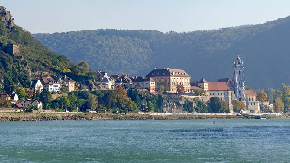 A riverside town with historic buildings and a prominent church tower.
