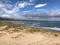 Una playa con dunas y olas.