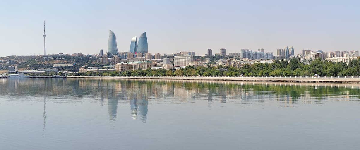 A city skyline with modern buildings, a river, and a Ferris wheel.