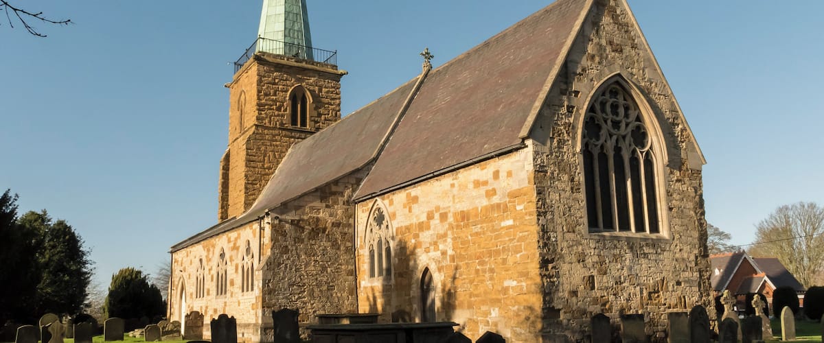 A historic church with a tall steeple and a large arched window.