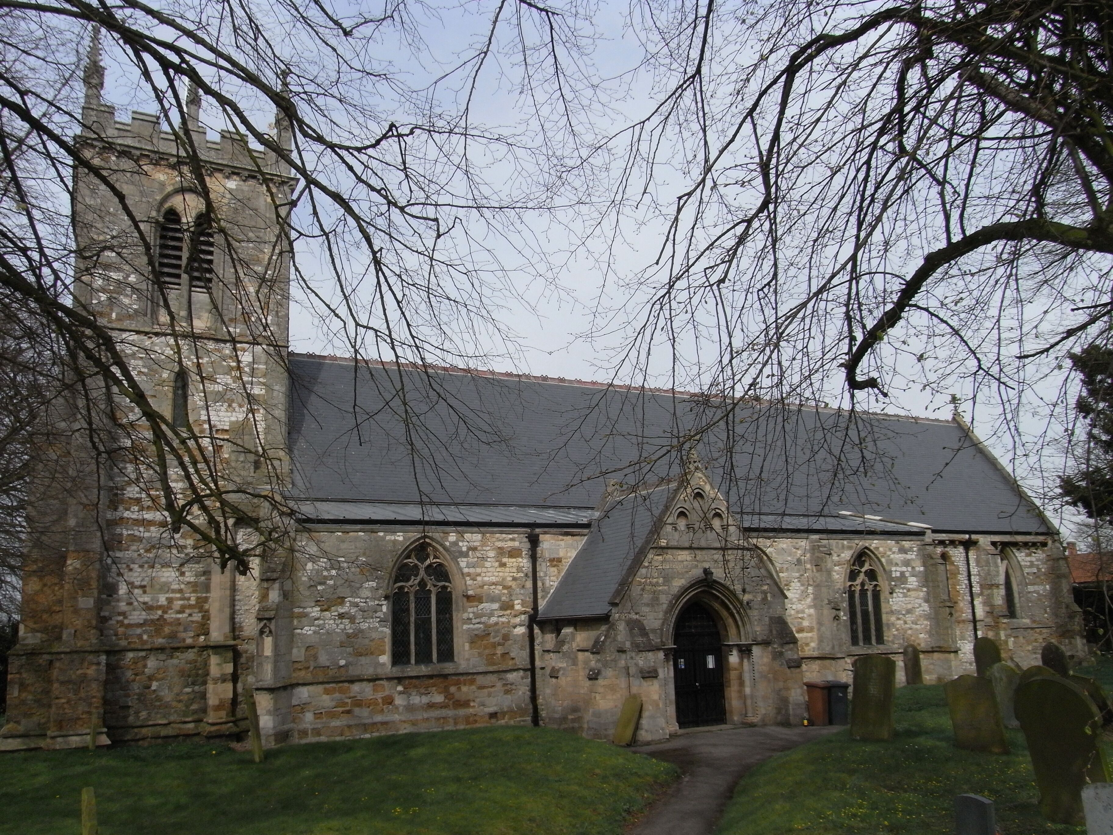 This is Grade 1 listed building. "Parish church. Late C12 - early C13 chancel, C13 tower, nave arcades and south door, C14 aisles, C15 tower parapet. Restorations of 1884 by J Fowler of Louth included rebuilding south porch, new nave and chancel roofs. Limestone, ironstone and chalk rubble and squared blocks with ashlar dressings; ashlar south porch. Lead roofs to aisles, slate roofs to remainder. West tower, 4-bay aisled nave with south porch and 3-bay chancel. 2-stage tower: moulded plinth, angle buttresses to first stage, quoins to second stage. Tall 1st stage has west lancet, cill string course, small lancet to south and clockface to west, moulded string course. 2nd stage has tall twin belfry openings with polygonal shafts in pointed chamfered reveal with shaft-rings. Corbel table, embattled parapet with C19 restored crocketed pinnacles.." www.britishlistedbuildings.co.uk/en-165883-church-of-sain... The church, which is difficult to photograph due to surrounding trees, contains a notable black Tournai marble font www.flickr.com/photos/dhwright/291713212/