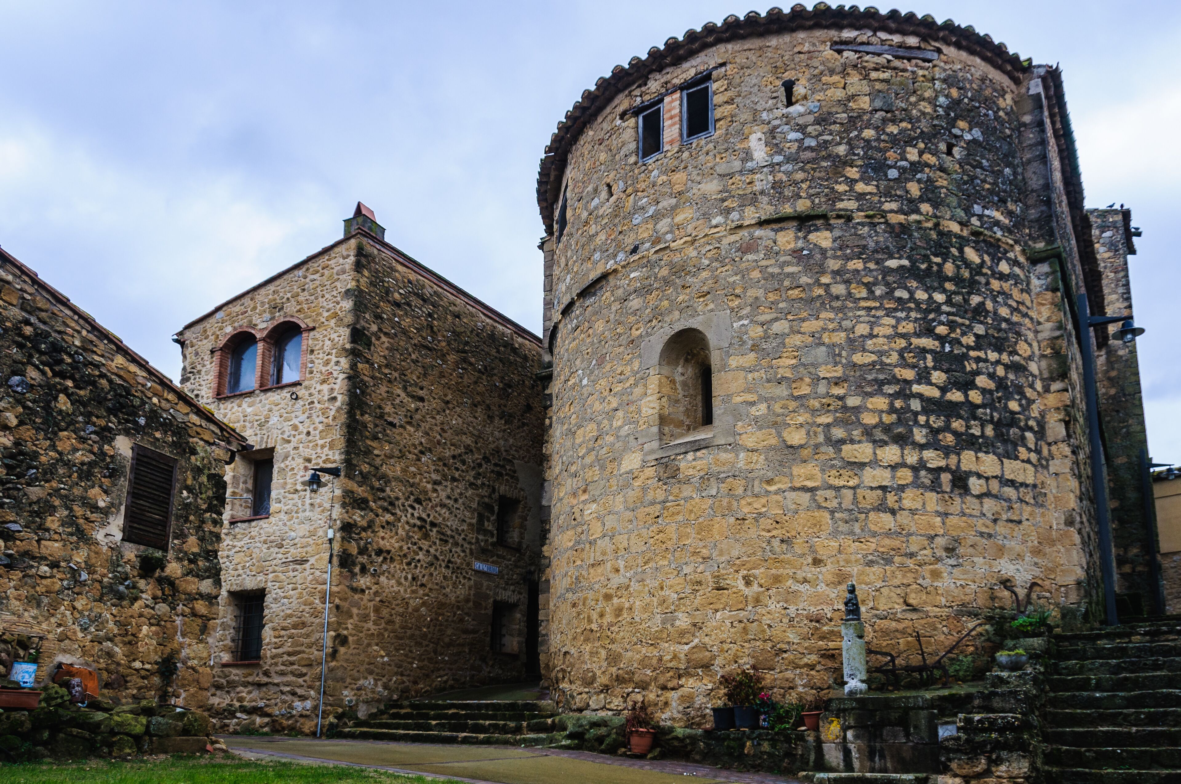 A historic stone building with a tower and arched windows.