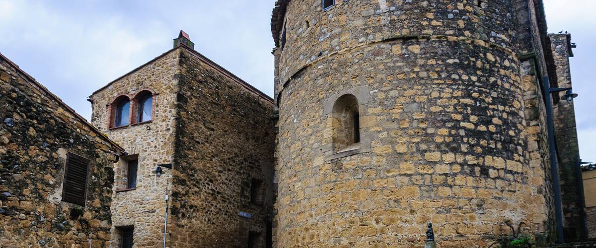A historic stone building with a tower and arched windows.