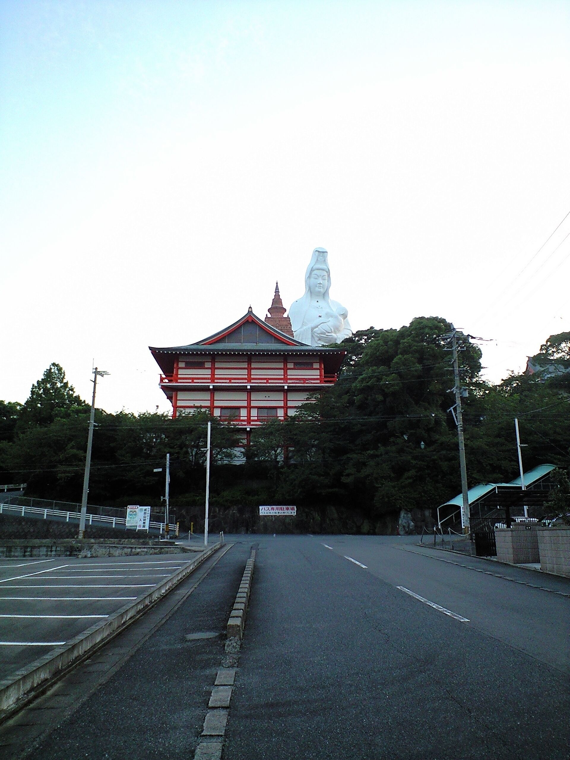 Um templo com uma grande estátua em frente.