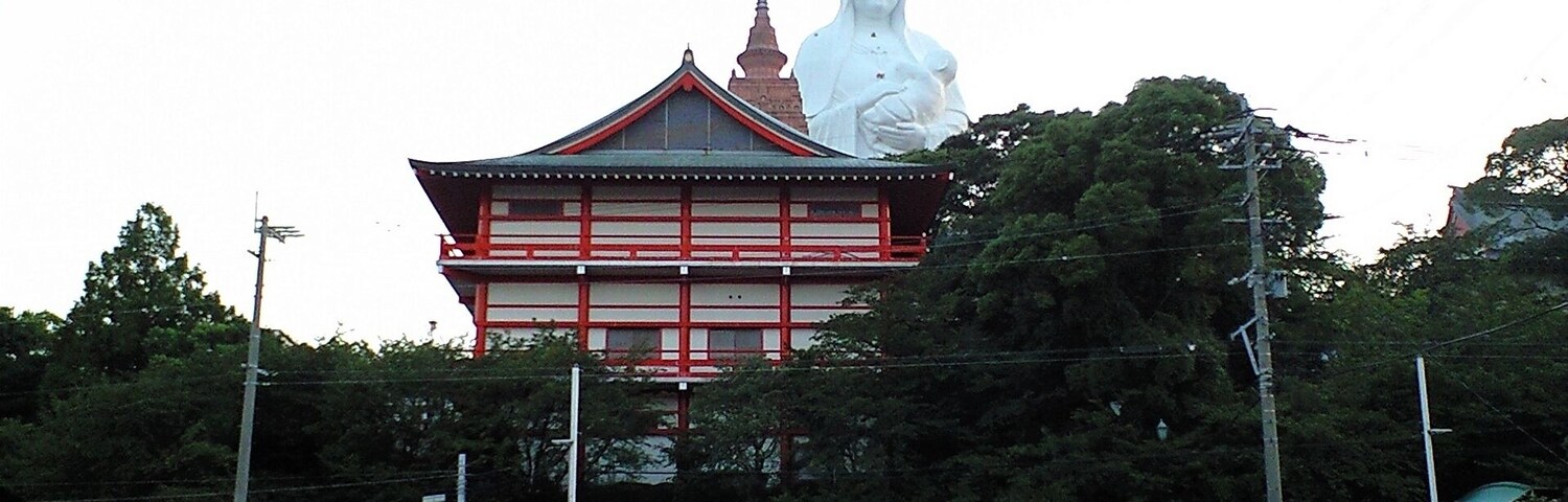 Um templo com uma grande estátua em frente.