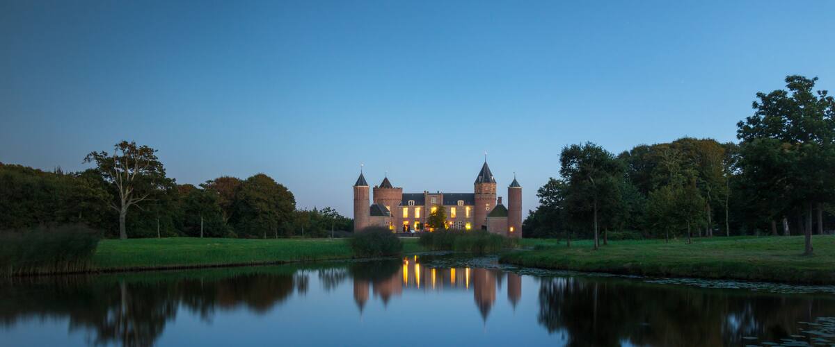 A castle with multiple towers and a moat with lily pads.