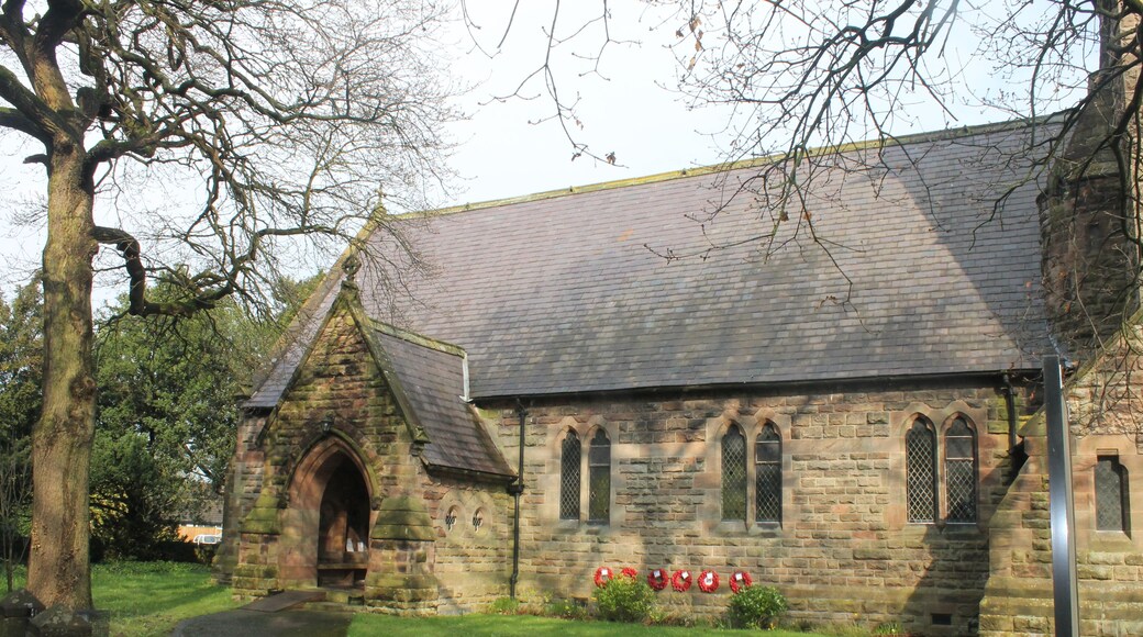 A stone church with a large arched entrance and a tiled roof.