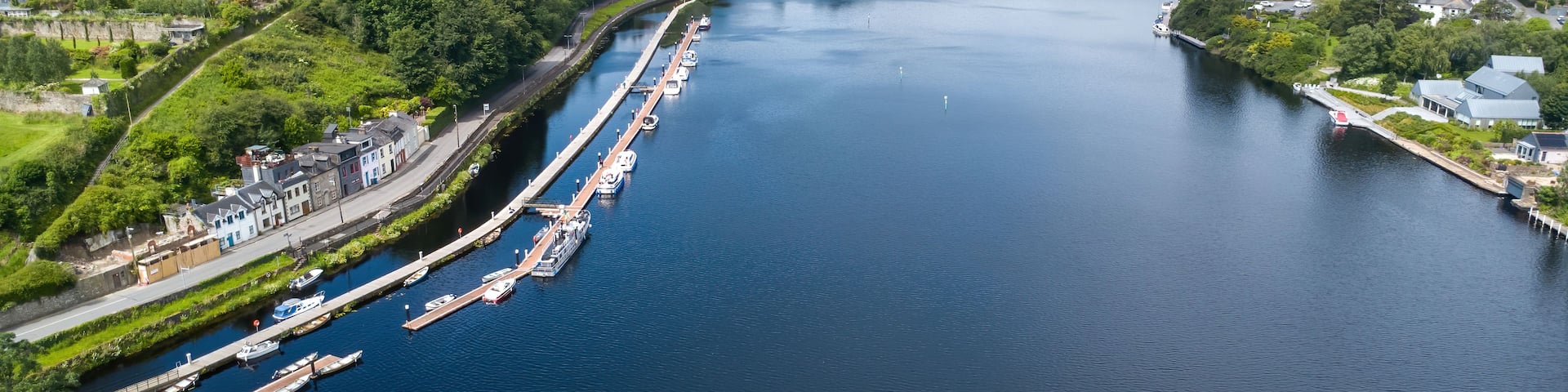A river with a dock, boats, and houses along the banks.