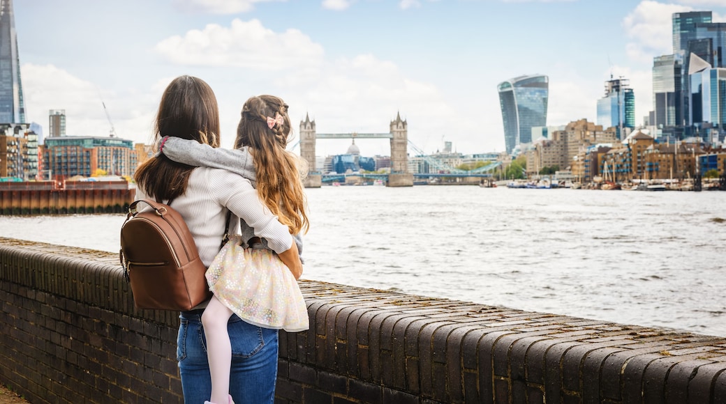 A mother and daughter on a city vacation looking at the skyline of London, England, with river Thames and Tower Bridge