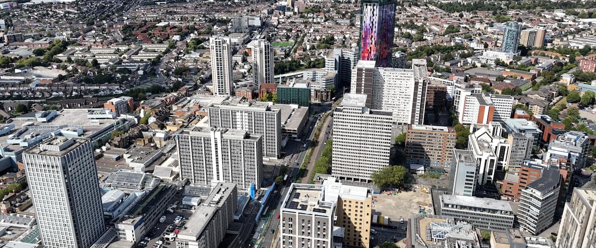 An aerial view of a cityscape with dense urban development, including high-rise buildings and a mix of commercial and residential structures.
