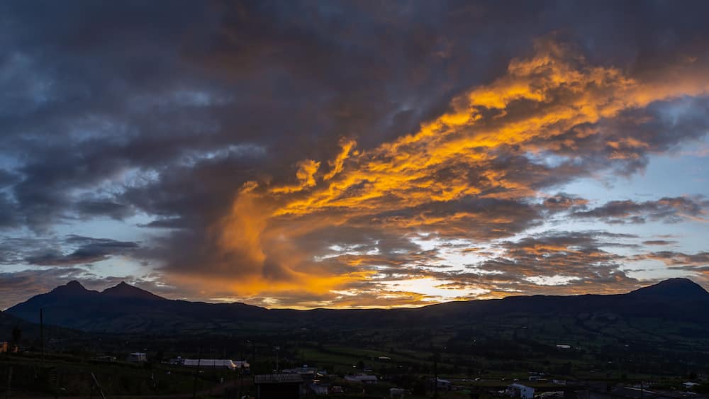 Ein Sonnenuntergang über Bergen mit einer markanten Wolkenformation.