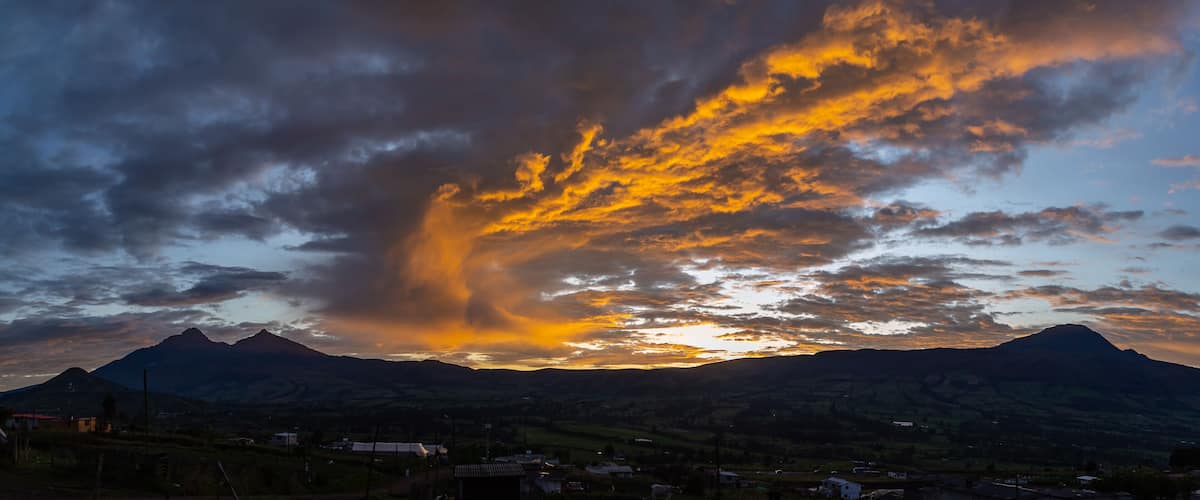 Un atardecer sobre montañas con una formación nubosa espectacular.