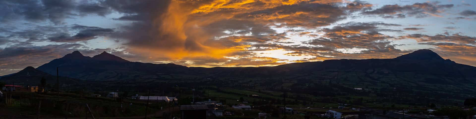 A sunset over mountains with a dramatic cloud formation.