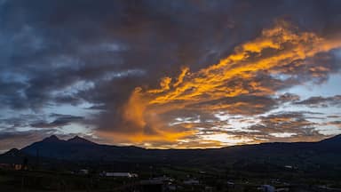Pôr do sol sobre montanhas com uma formação de nuvens dramática.