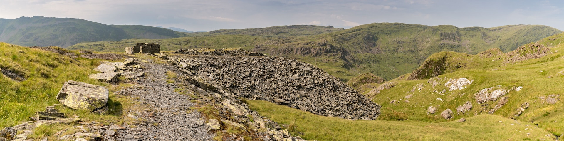 A rocky path leading to a stone structure in a mountainous landscape.
