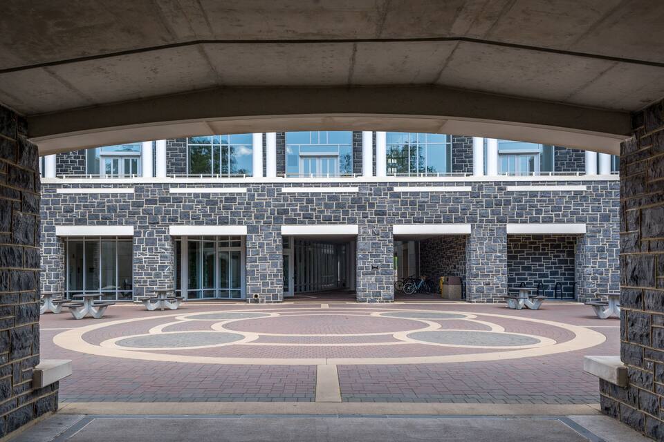 A building with a stone facade, large windows, and a circular courtyard.