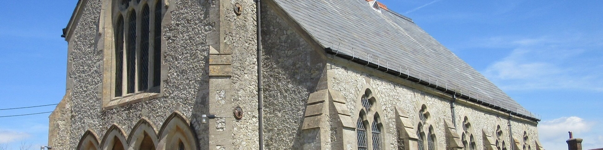 Eine steinerne Kirche mit steilem Dach und Rundbogenfenstern.