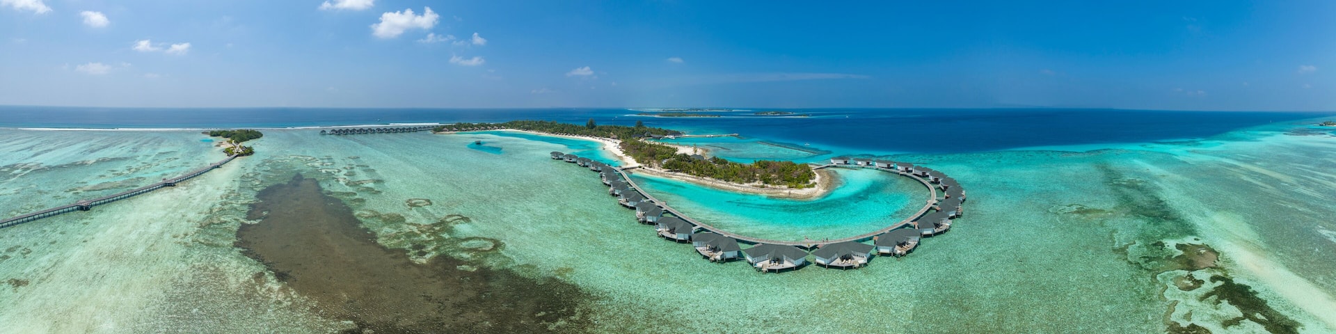 Water bungalows on Kanuhura Island under blue sky in Maldives