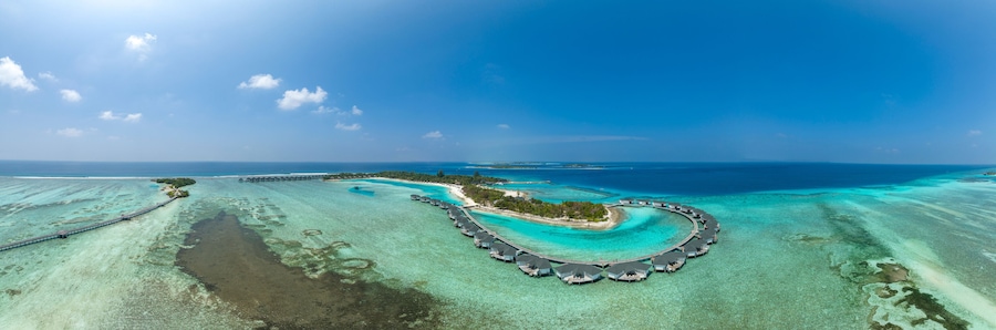 Water bungalows on Kanuhura Island under blue sky in Maldives
