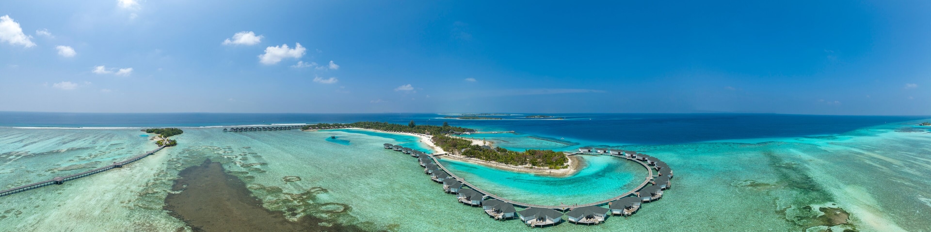 Water bungalows on Kanuhura Island under blue sky in Maldives