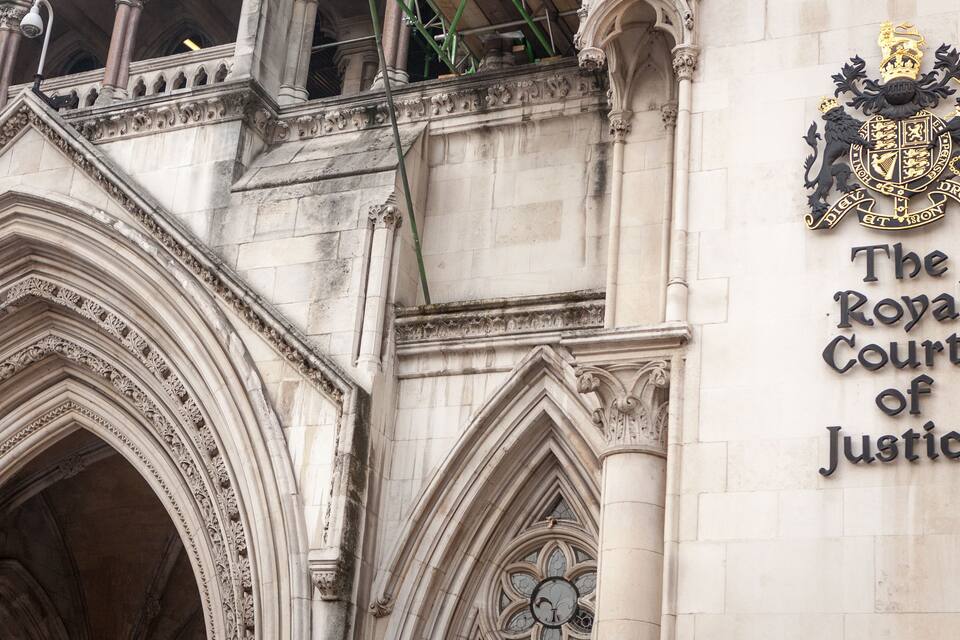 The entrance of The Royal Courts of Justice with Gothic architecture and a coat of arms.