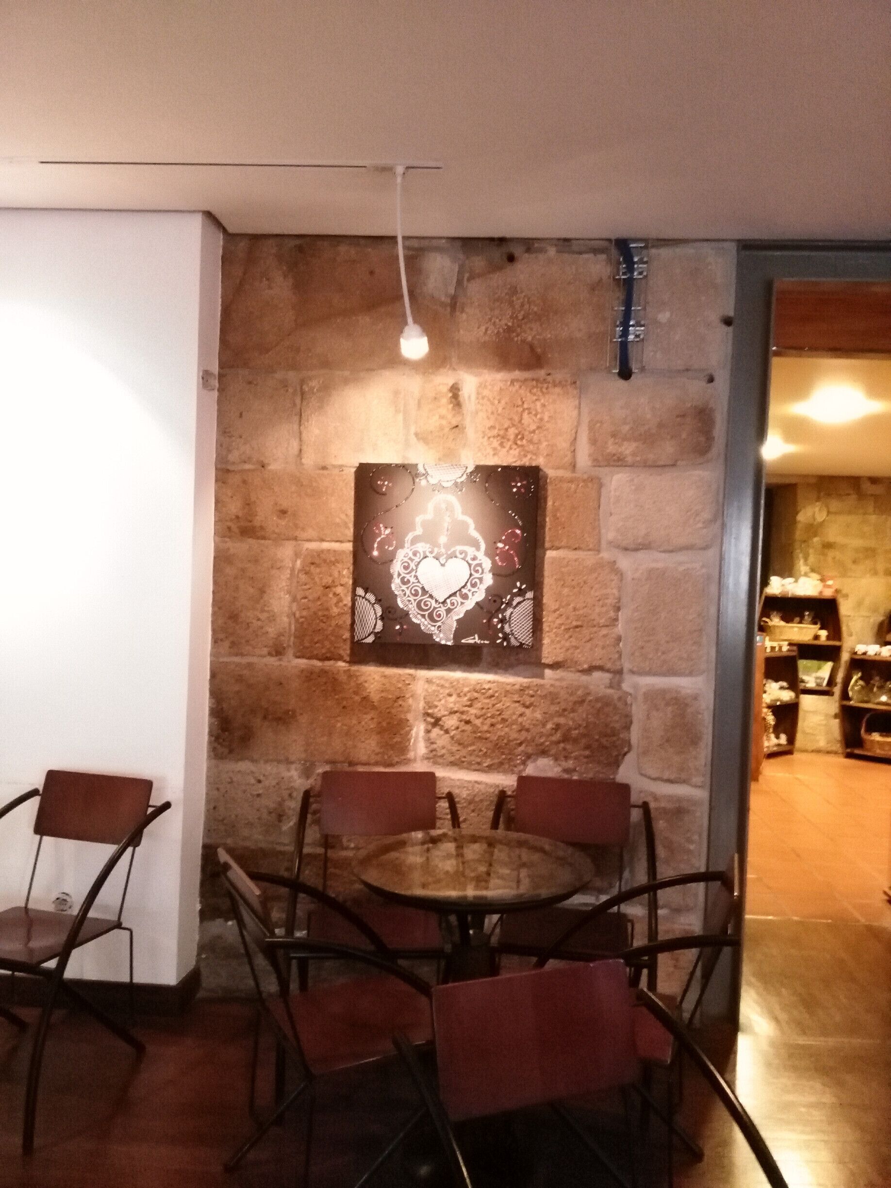 A dining area with a stone wall, a round table, and six chairs.