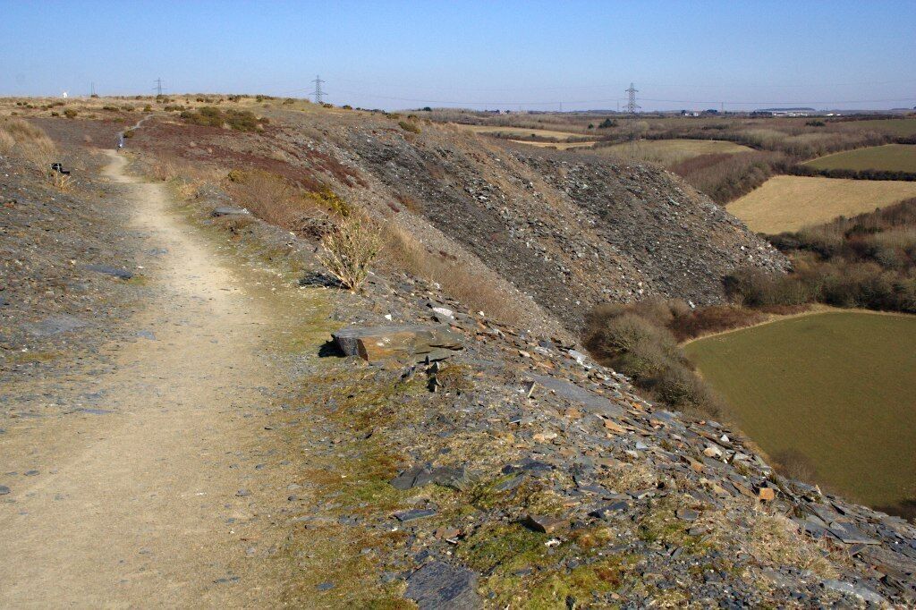 On the Spoil Heap at Delabole The scale and height of the waste from the pit at Delabole is perhaps as impressive as the pit itself. There is an easy footpath around the top of the waste tip.
