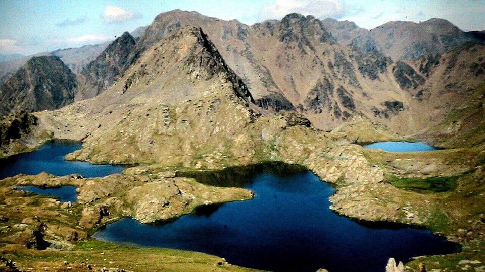 A mountainous landscape with a large lake surrounded by rugged terrain.